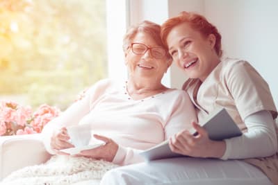 happy senior woman with female caregiver