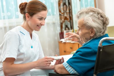 image of a woman caregiver assisting the elderly woman